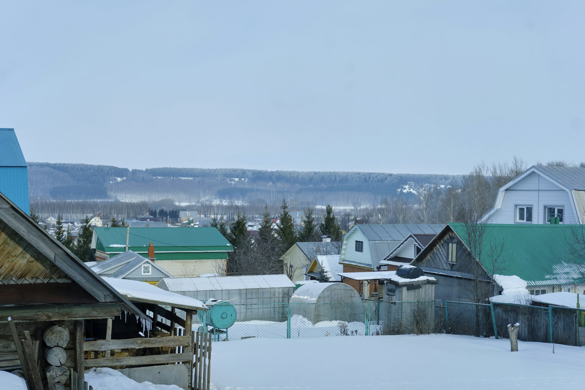 Rustic house in winter, overlooking the forest